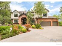 Charming home with a brick archway and a beautifully landscaped front yard with mature trees at 1323 Swallow Ct, Boulder, CO 80303
