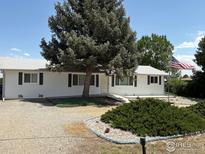 Charming ranch-style home with mature landscaping and a gravel driveway at 13600 Elmore Rd, Longmont, CO 80504