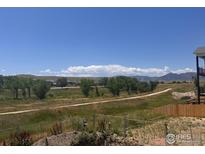 Expansive backyard view featuring a walking path, open space, and distant mountains under a vibrant blue sky at 2515 Andrew Dr, Superior, CO 80027