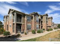 A stunning exterior view of a modern apartment complex with balconies and beautiful stone accents at 3155 Blue Sky Cir # 16-103, Erie, CO 80516