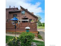 Charming home exterior featuring a cozy porch, garden, and vibrant flowers in a well-maintained front yard at 6504 Ralston Rd, Arvada, CO 80002