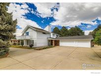 Well-maintained exterior of a white home featuring an attached three-car garage and large concrete driveway at 6668 Walker Ct, Niwot, CO 80503