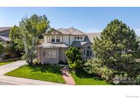 Charming two-story home boasts manicured lawn, mature trees, and brick accents for a welcoming curb appeal at 888 Northern Way, Superior, CO 80027