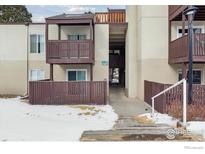 Beige condo building featuring wood trim, balconies, and walkway under an overcast sky at 9995 E Harvard Ave, Denver, CO 80231