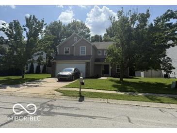 Charming two-story home with mature trees, well-manicured lawn, and attached two-car garage at 17902 Cristin Way, Westfield, IN 46062