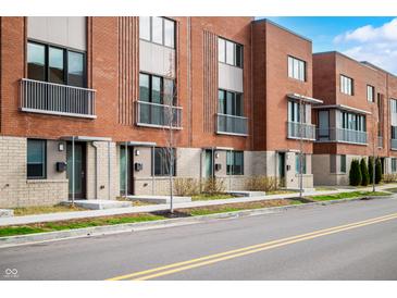 Modern brick townhomes feature private balconies and well-maintained landscaping along a tree-lined street at 822 7Th St, Columbus, IN 47201