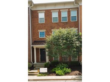 Charming brick townhome featuring a covered entryway and well-maintained landscaping at 6343 Central Blvd, Whitestown, IN 46075