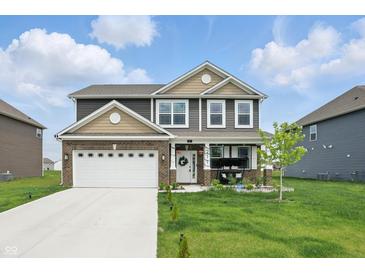Charming two-story home featuring a well-manicured lawn and attached two-car garage at 211 Walker Dr, Whiteland, IN 46184