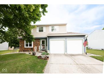 Charming two-story home with a two car garage, landscaped yard, and an American flag at 605 Brentwood E Dr, Plainfield, IN 46168
