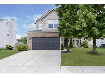 Two-story house with a gray garage door and landscaped lawn at 10561 Sand Creek Blvd, Fishers, IN 46037