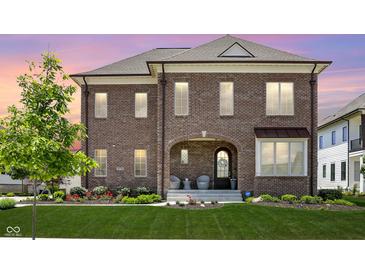 Charming two-story brick home with manicured lawn, decorative plantings, and a welcoming arched entryway at 15776 Allure Dr, Westfield, IN 46074