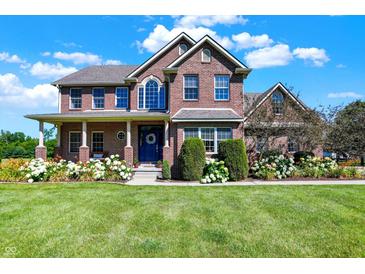 A beautiful brick home with a well-manicured lawn and lush hydrangea bushes at 13208 State Road 32 E, Noblesville, IN 46060