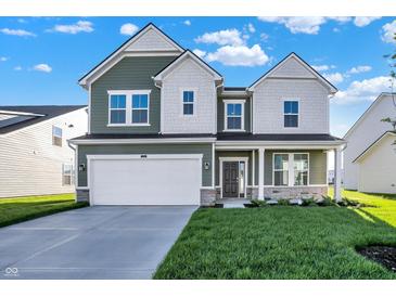 Two-story house with green and white siding, a large driveway and landscaped lawn at 573 Carroll St, New Whiteland, IN 46184