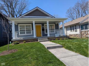 Charming home featuring a welcoming front porch with white columns and a bright yellow front door at 3636 Salem St, Indianapolis, IN 46208