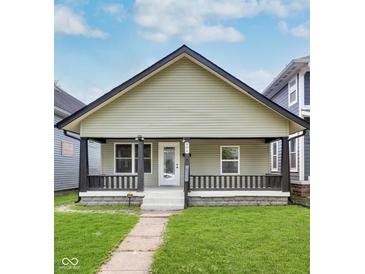 Charming bungalow with a covered front porch, black trim, and a well-maintained lawn at 906 N Parker Ave, Indianapolis, IN 46201
