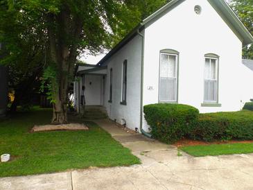 White brick house with green trim, landscaping, and a walkway at 25 W Pennsylvania St, Shelbyville, IN 46176