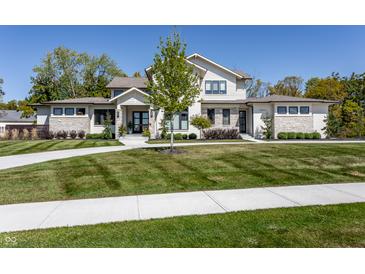 Inviting two-story home with stone accents, manicured lawn, and a circular driveway at 340 Beechwood Farm Ln, Indianapolis, IN 46260