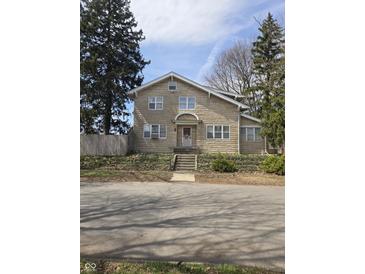 Attractive two-story home with stone exterior, steps leading to the front door, and mature trees at 927 E Southern Ave, Indianapolis, IN 46203