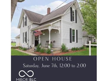 Charming two-story house with a cozy front porch and an American flag, surrounded by a well-manicured lawn at 47 Meadow Dr, New Palestine, IN 46163