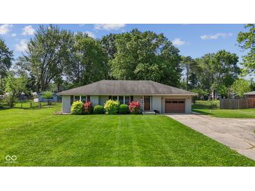 Charming single-story home featuring a well-maintained lawn, colorful bushes, and an attached one-car garage at 105 Tulip Dr, Indianapolis, IN 46227
