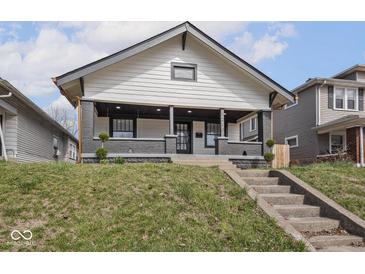 Charming two-story home featuring a covered porch and professionally landscaped front yard at 1210 Finley Ave, Indianapolis, IN 46203