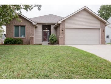 Charming single-story home featuring a well-maintained lawn, brick accents, and an attached two-car garage at 5964 Laramie Trl, Columbus, IN 47203
