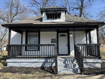 Charming home features a covered front porch with black railings and updated facade at 2869 Stuart St, Indianapolis, IN 46218
