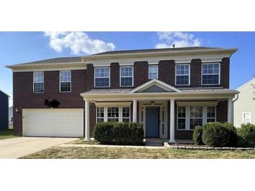 Charming two-story brick home featuring a well-maintained front yard and an attached two-car garage at 5656 Buck Dr, Noblesville, IN 46062