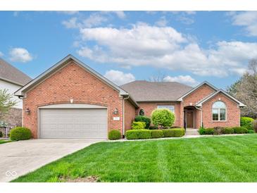 Charming brick home with a well-manicured lawn, beautiful landscaping, and an attached two-car garage at 691 Walnut Woods Dr, Greenwood, IN 46142