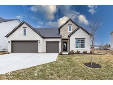 Charming brick home featuring a three car garage and well-manicured lawn at 4982 Reavie Ct, Noblesville, IN 46062