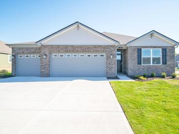 Charming, single-story brick home with a spacious three-car garage and a well-manicured lawn at 231 Lar Lan Dr, Danville, IN 46122