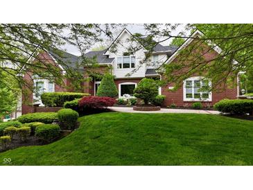 Charming two-story brick home with a lush green lawn and beautifully landscaped garden at 2838 Silverwood Ln, Greenwood, IN 46143