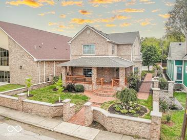 Charming brick home showcasing a well-manicured front yard, inviting front porch, and warm, classic architecture at 1817 Bellefontaine St, Indianapolis, IN 46202