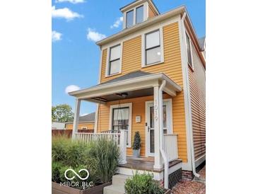 Charming yellow two-story home with a cozy front porch and well-maintained landscaping at 1019 Central Ave, Indianapolis, IN 46202
