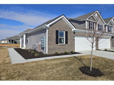Charming home showcasing a well-maintained lawn, brick accents, and a convenient two-car garage at 6272 Wasco Dr, Whitestown, IN 46075