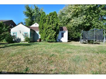 A charming home with a spacious front yard, mature trees, and a trampoline at 850 S Holmes Ave, Indianapolis, IN 46221