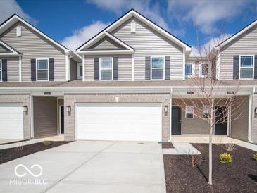 Charming townhome featuring a brick facade, two-car garage, and modern architectural details at 6296 Wasco Dr, Whitestown, IN 46075