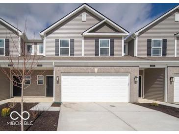 Charming townhome featuring a two-car garage, gray siding, black shutters and a concrete driveway at 6304 Wasco Dr, Whitestown, IN 46075