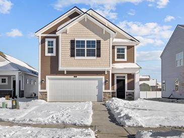 Charming two-story home featuring a two-car garage, classic brown siding, and a snow-covered front yard at 5143 Rolling Meadow Blvd, Indianapolis, IN 46237