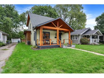Charming two-story home with a covered front porch and manicured lawn at 6129 Crittenden Ave, Indianapolis, IN 46220