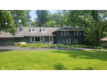 Charming two-story home featuring a beautifully landscaped front yard and a classic architectural design at 6205 Bramshaw Rd, Indianapolis, IN 46220