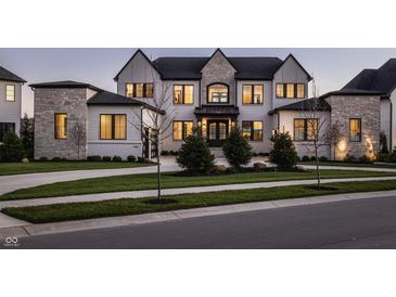 Stunning two-story home with a combination of white brick and stone, complemented by a well-manicured lawn at 10937 Pete Dye Rdg, Zionsville, IN 46077