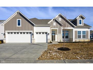 Beautiful home exterior featuring a three-car garage and stone accents, blending style and functionality at 15846 Vitalize Run, Fishers, IN 46040