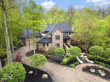 Majestic aerial view of a luxurious home with lush gardens and circular drive at 9468 Sullivan Pl, Zionsville, IN 46077