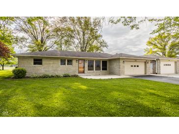 Charming single-story home featuring a stone facade, attached two-car garage, and lush green lawn at 5861 S 100 W, Fountaintown, IN 46130