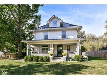Two-story house with gray brick and white siding, metal roof, and porch at 4902 N Park Ave, Indianapolis, IN 46205
