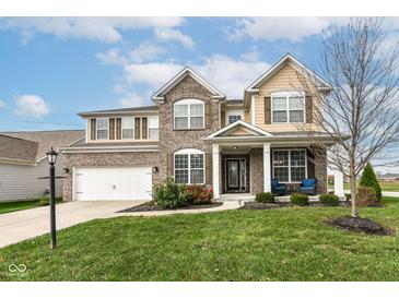 Two-story brick home with a welcoming front porch and landscaped lawn at 6252 Sugar Maple Dr, Zionsville, IN 46077