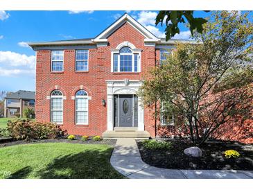 Charming two-story brick home with a landscaped yard, gray door, and an inviting walkway to the front door at 794 Princeton Ln, Westfield, IN 46074