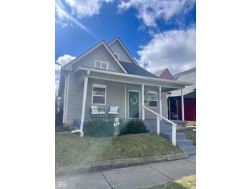 Charming grey home with a welcoming front porch, featuring white railings and a lovely wreath on the front door at 1709 Hoyt Ave, Indianapolis, IN 46203