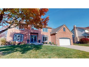 Stunning two-story red brick home with attached garage, lush lawn, and vibrant fall foliage at 1160 Mt Vernon Dr, Greenwood, IN 46142